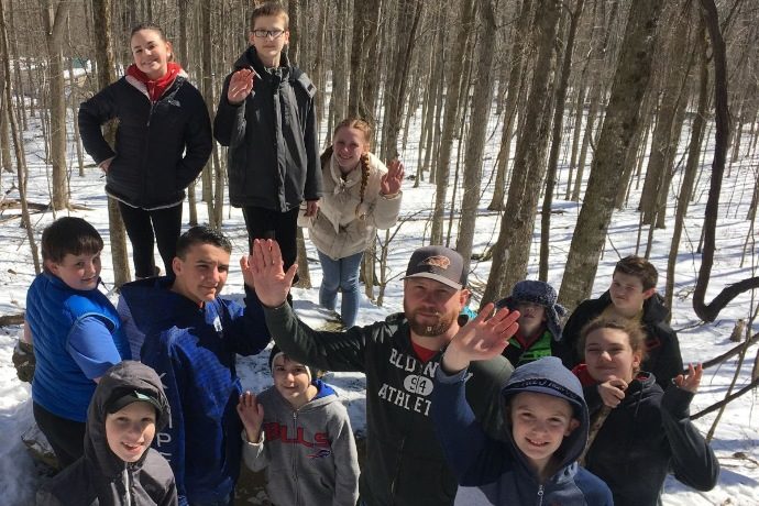 Group picture outdoors in the snow at rock mountain.