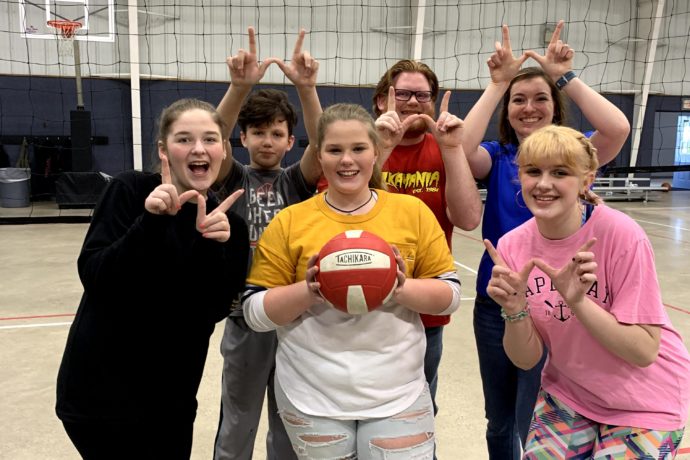 Group playing volleyball in the gym.